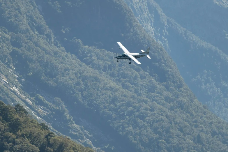 a plane flying low to the ground in a mountain range