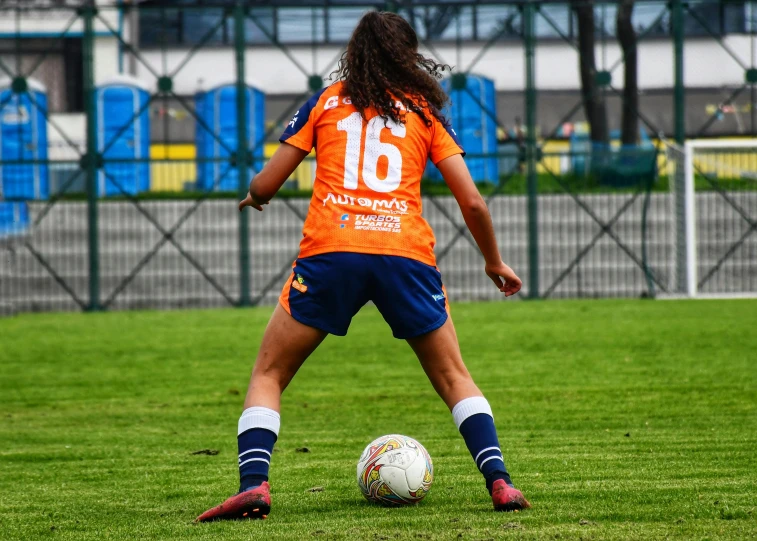 a woman kicking a soccer ball on a field