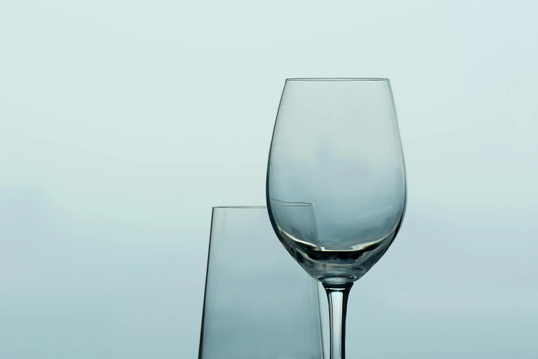 a tall glass sitting next to a smaller glass