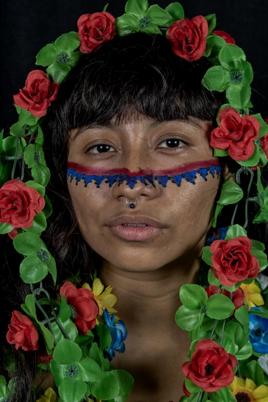 the girl is adorned in various flowers and foliage