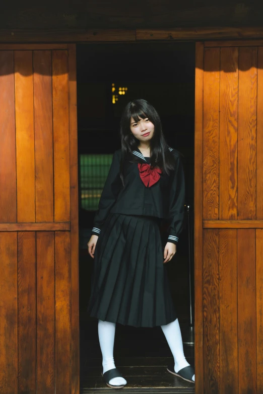 a girl standing in the doorway with her head bowed