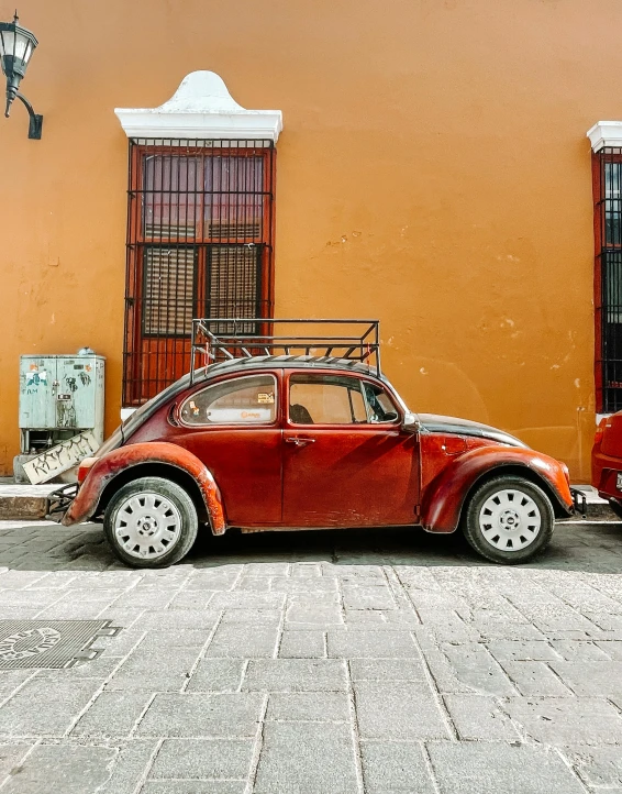 a vintage bug is parked in front of a building