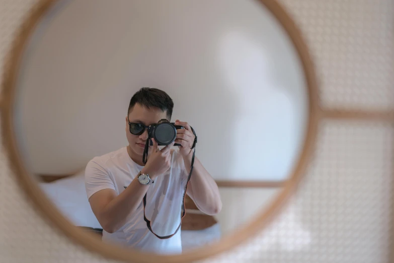 a man takes his own po with a camera in the mirror