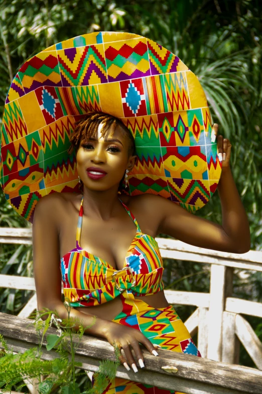 a woman in yellow and green bikini holding a parasol