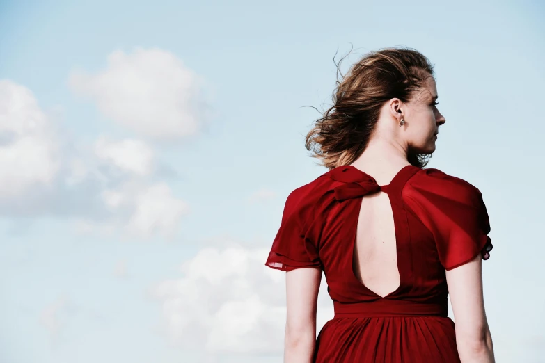 a  in a red dress and a sky background
