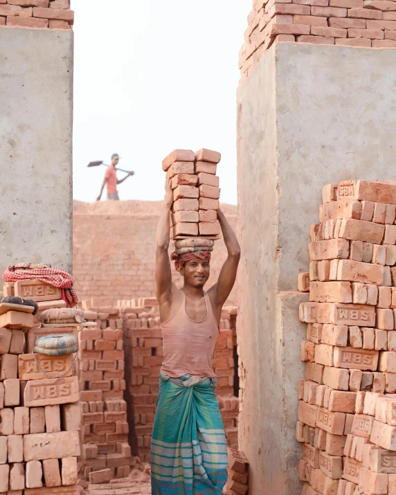 a woman carrying brick near some brick wall