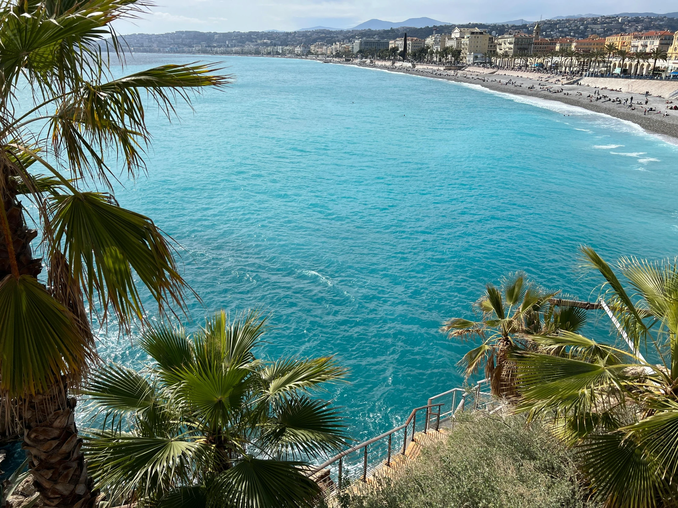 blue water is pictured from high up on the hill side