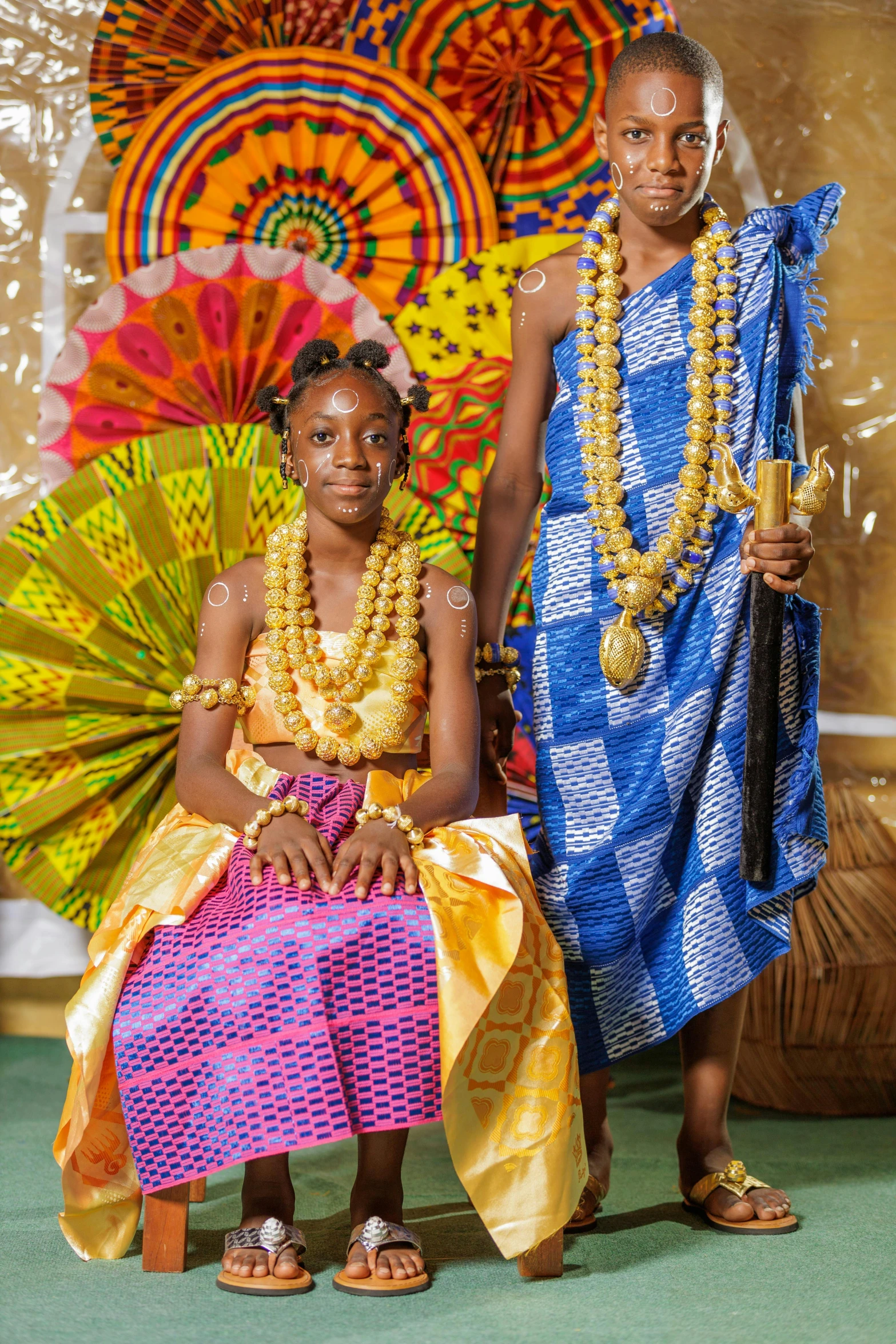 two girls dressed in bright african clothing stand next to each other