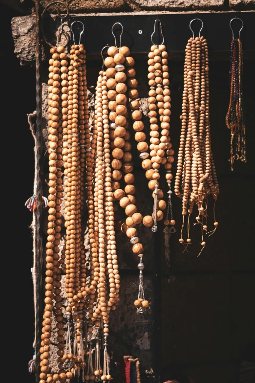 a wall is decorated with wooden beads and other items