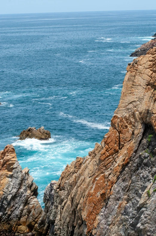 a couple of birds sitting on top of a rock near the ocean