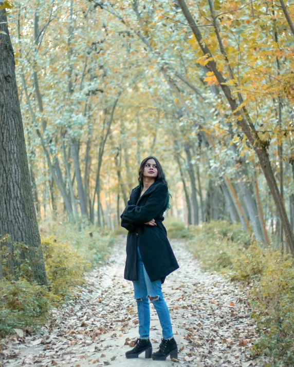 an attractive young woman standing in the woods