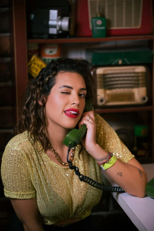 a woman sits on a table with a green telephone