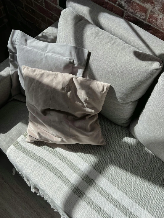 pillows are on the top of an arm of a couch