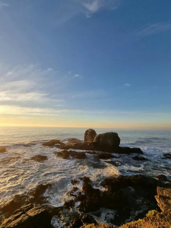 a person sitting on a bench looking out to the ocean