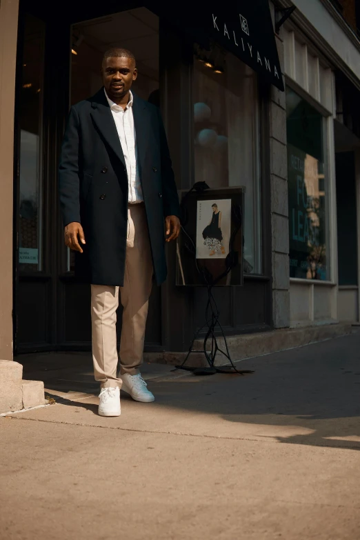 an african american man poses on the sidewalk