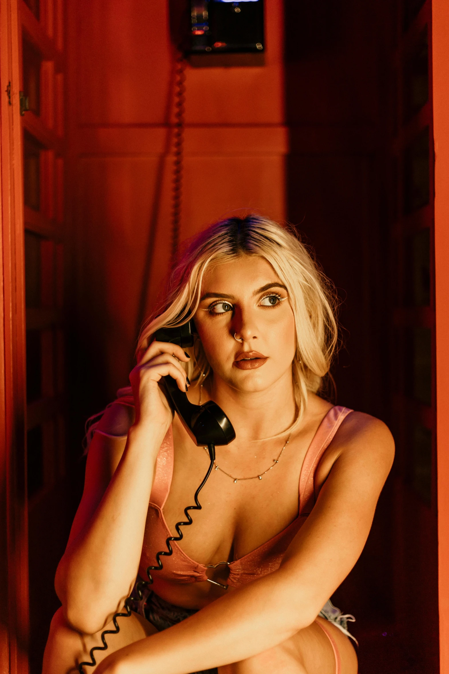 a woman sits in the hallway on the telephone