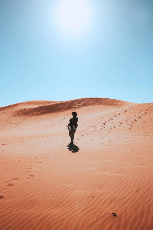 man walking through the sand in a desert