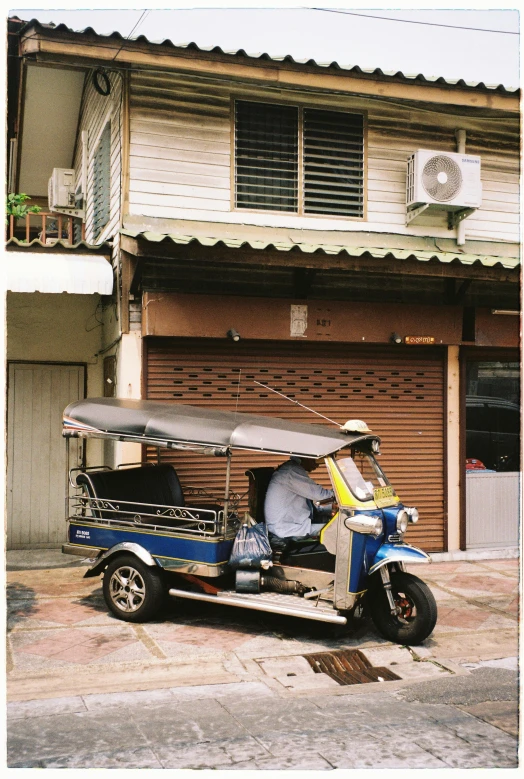 a sidecar is parked outside of a garage with its door open