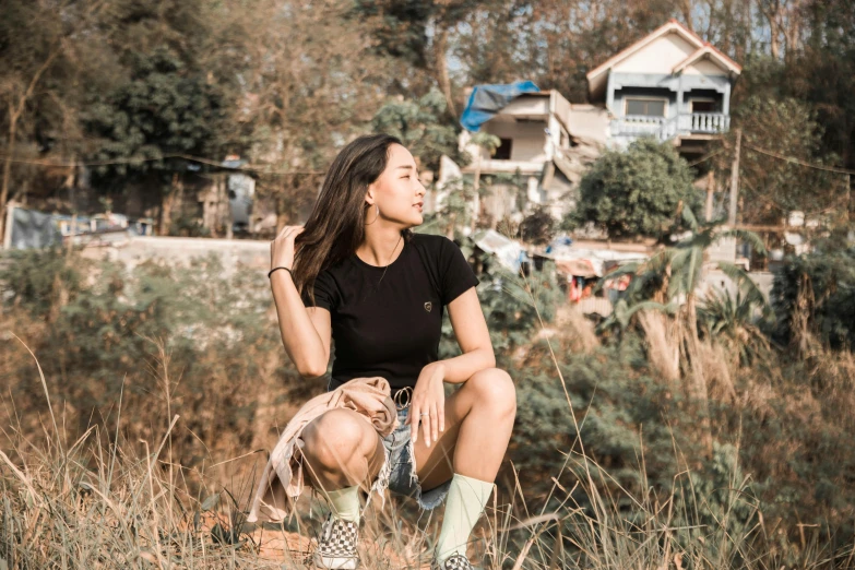 a woman in short shorts sitting in a field