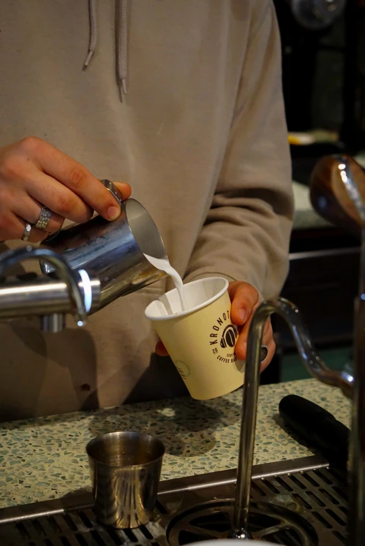 person at a sink using coffee maker pouring water