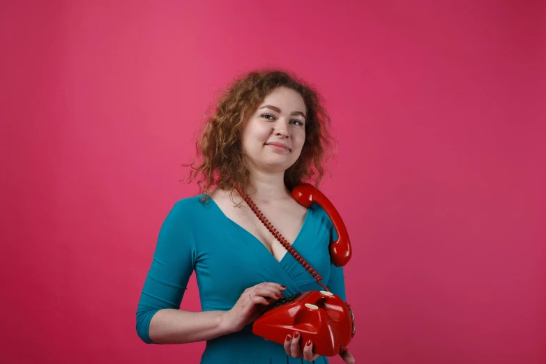 a woman holding two red plastic hearts, looking at the camera