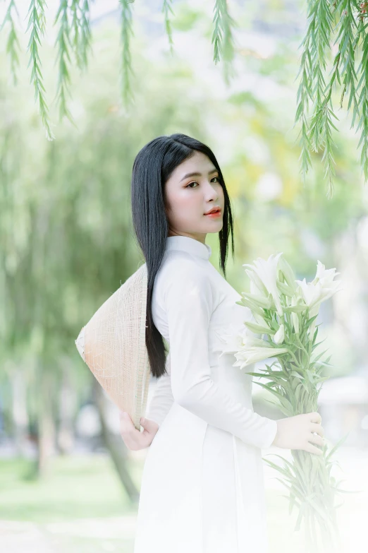 a asian woman holds some flowers while posing for a po