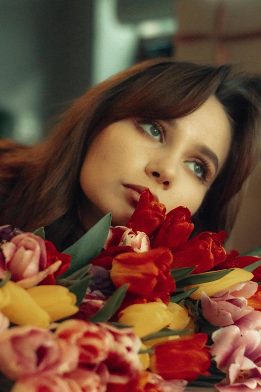 a woman peeking her face down from some flowers