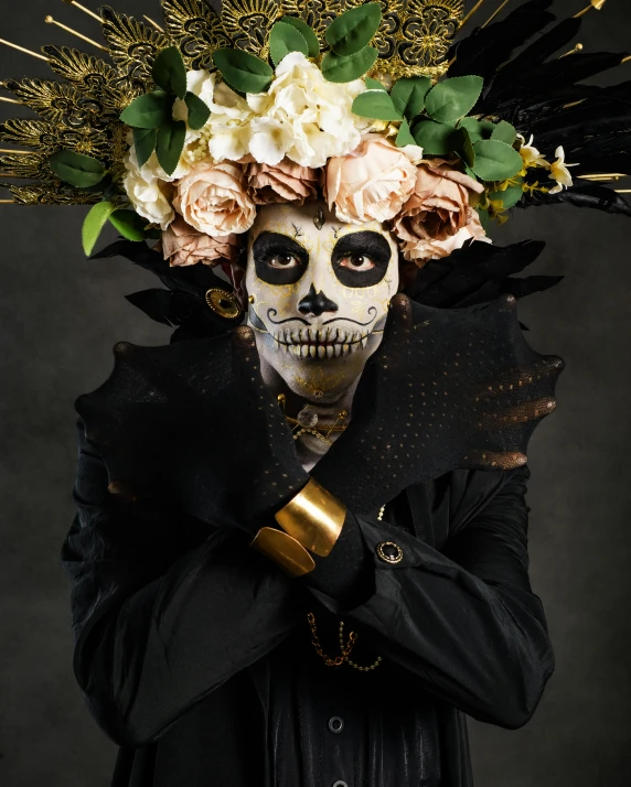 a man in a suit and skeleton head covering with flowers