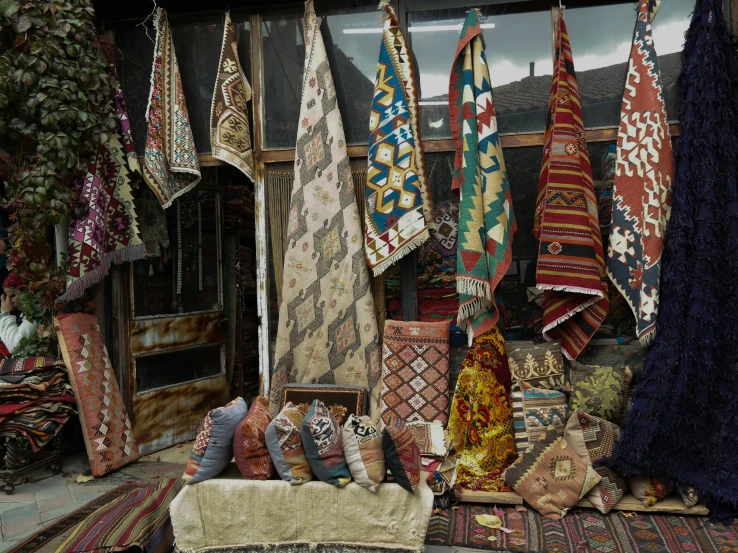 a pile of oriental blankets sit in front of a shop