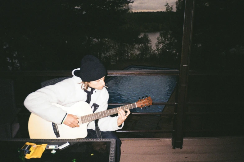 a child sitting on a bench playing an electric guitar