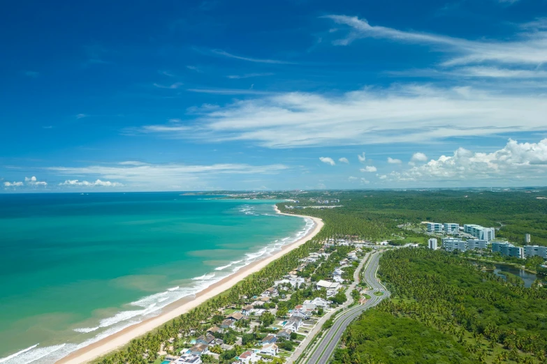 an aerial view of the beach and ocean, with buildings in the background