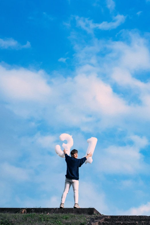 a person stands on a ledge while holding letters