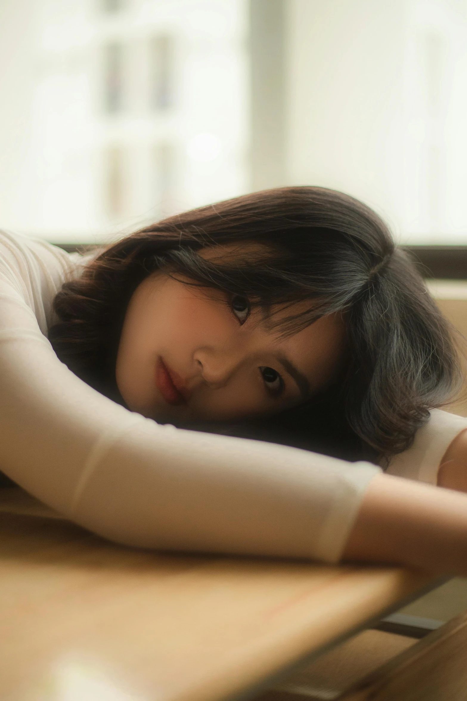 a woman with dark hair leaning on a table