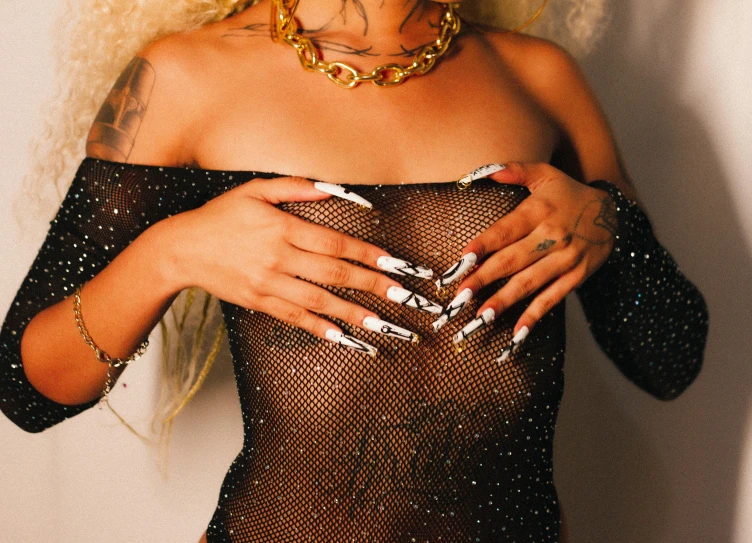 a woman with tattoos, wearing a fishnet dress