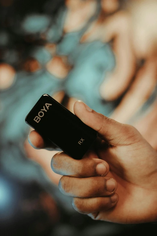 a hand holding a black object in the air