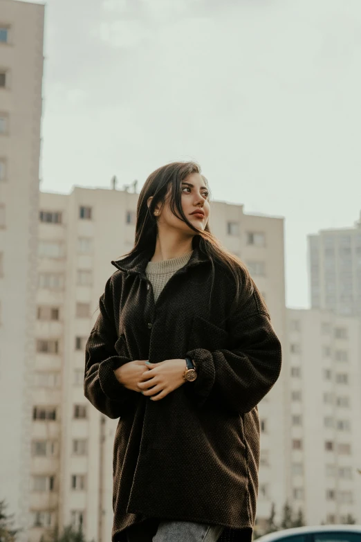 a woman with long hair stands outside of the city