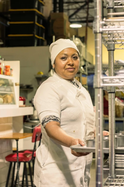 a woman is holding a tray in a kitchen