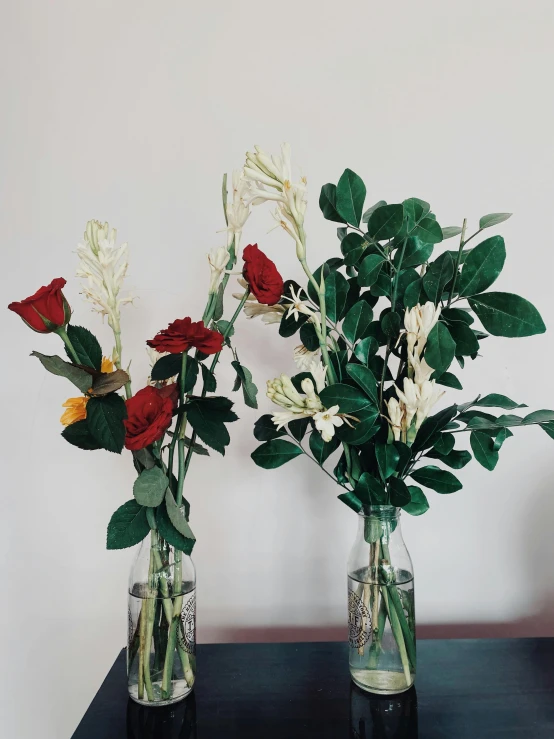 two vases of flowers sit on a table