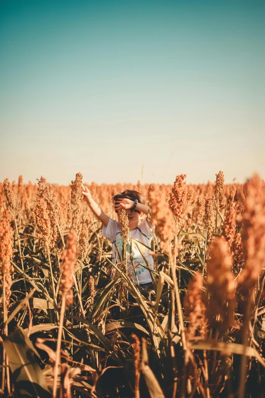 a man in a field waving at the camera