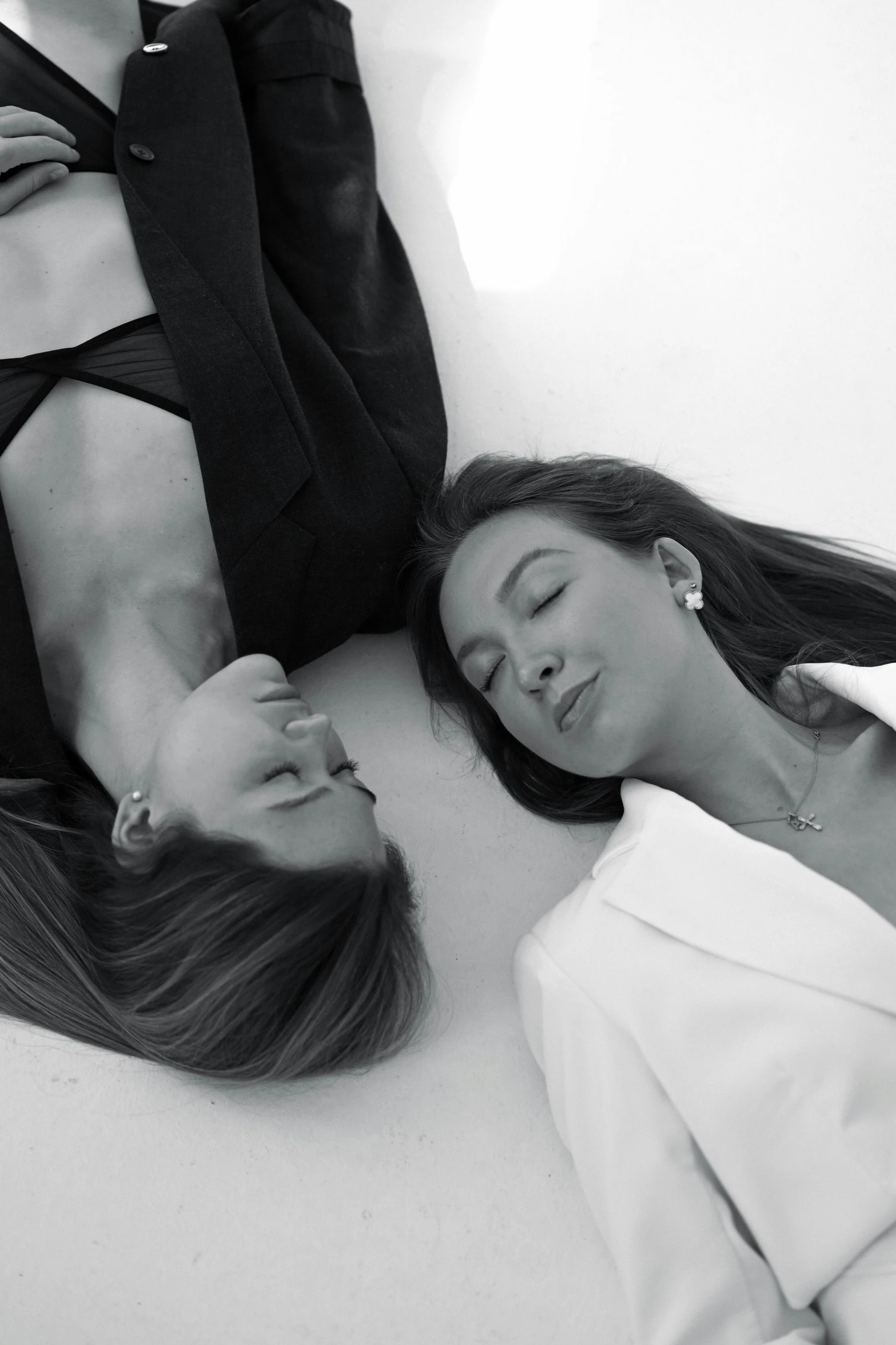 two women wearing ties are lying down on the floor