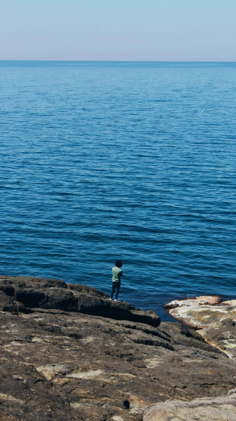 the man is by the ocean on the rocks