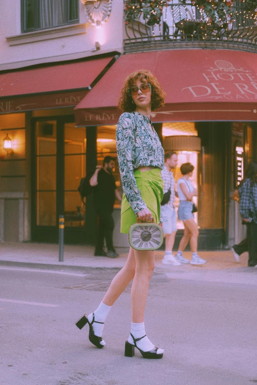 a woman is standing on the sidewalk in front of a store