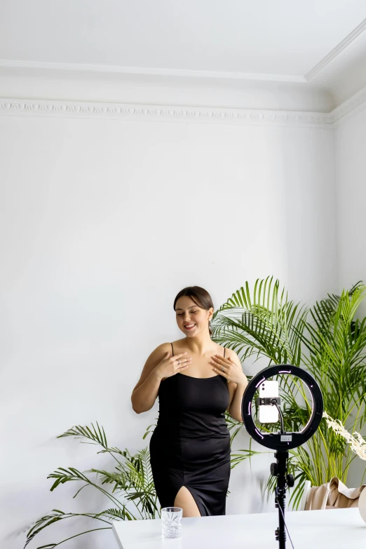 a woman wearing a black bodysuit standing near a camera
