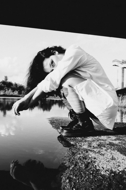 black and white image of girl crouching against wall