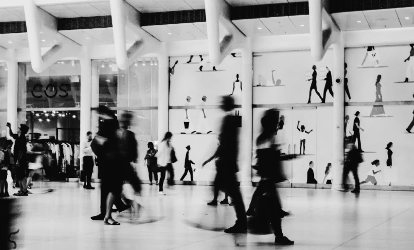 many people walking around in a large room with lots of sculptures