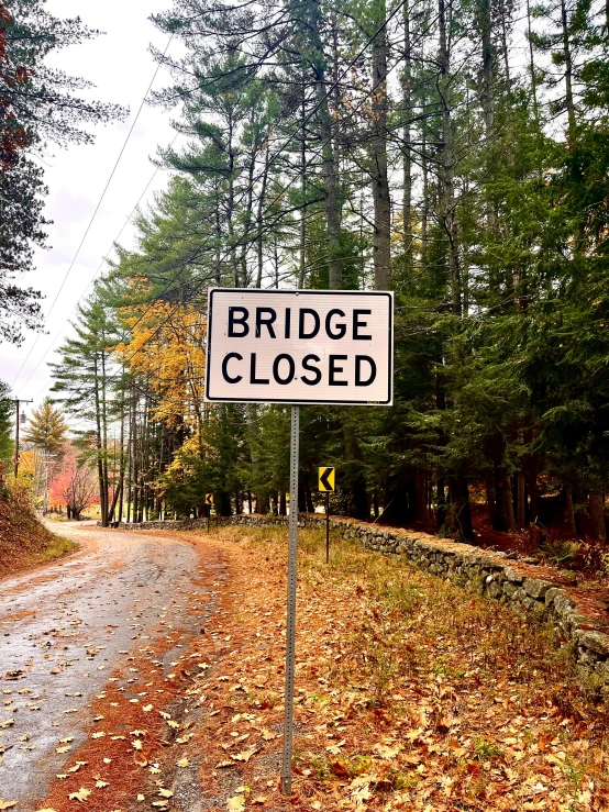 a road is closed as a sign sits on the road