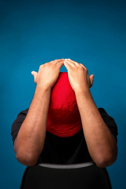 a man covering his face with his hands