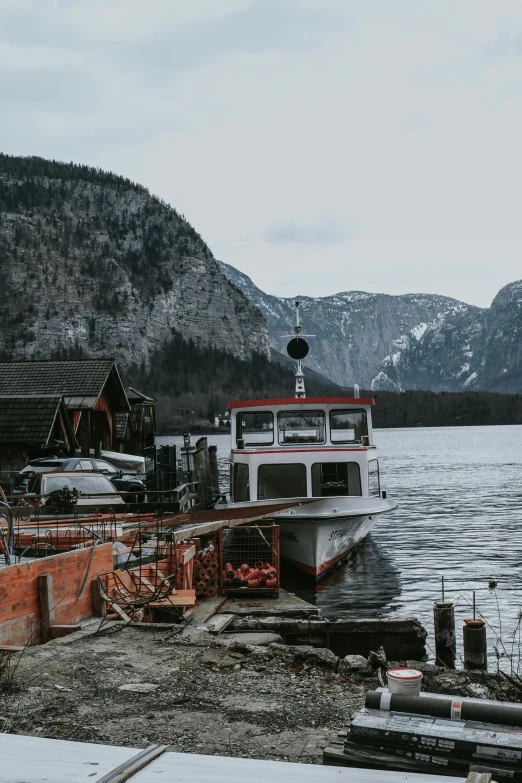 a small ferry parked next to a mountain