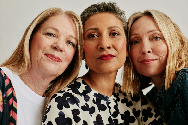 three women standing close together and smiling