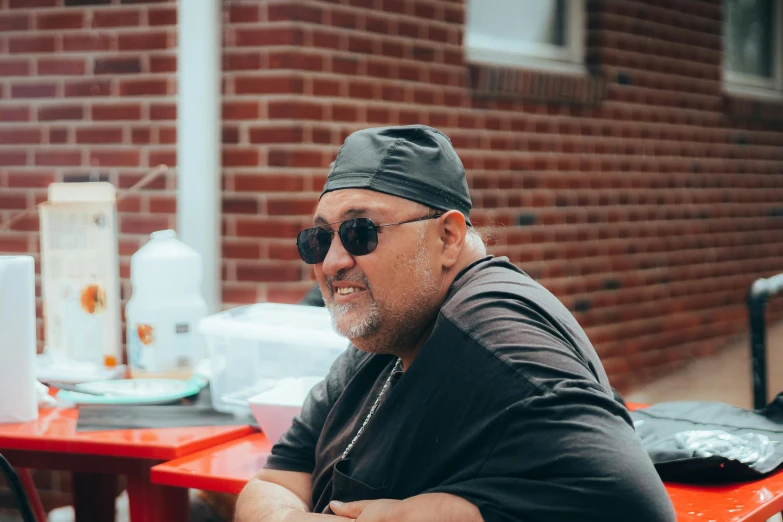 the man smiles at the camera while he sits down